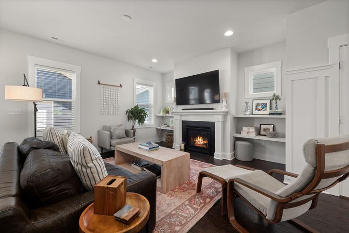 White mantel fireplace facing armchairs in a living room