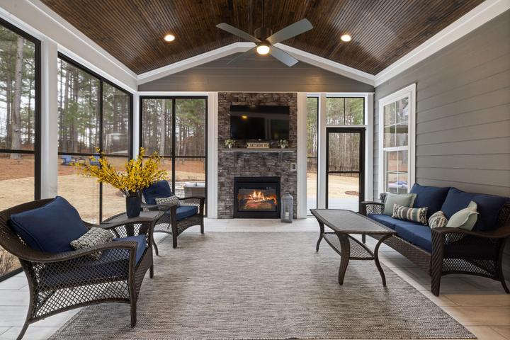 Enclosed patio with a stone fireplace and ceiling fan